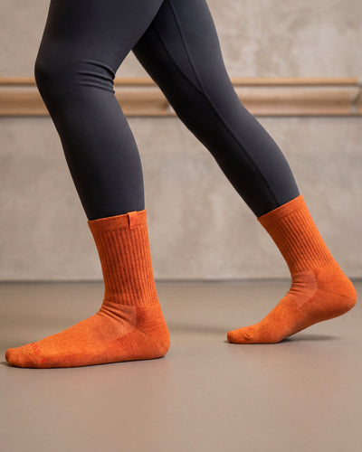 Bulg 788 Bali Orange crew socks in athletic use with vivid heathered orange ribbed cushioning