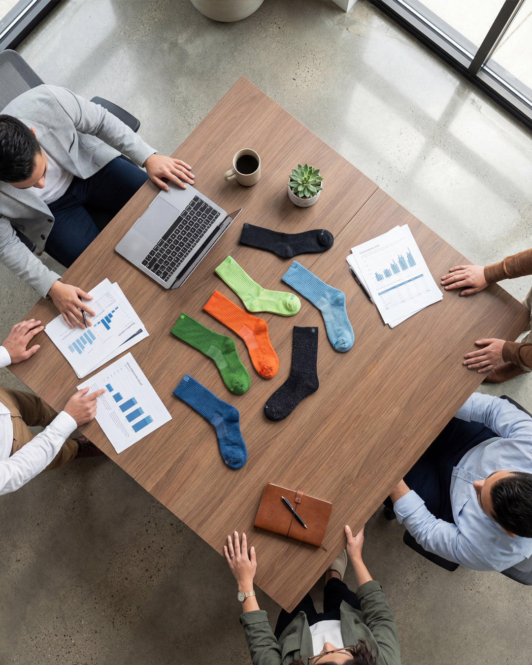 Aerial view of a team meeting with colorful Bulg crew socks scattered across a wooden conference table