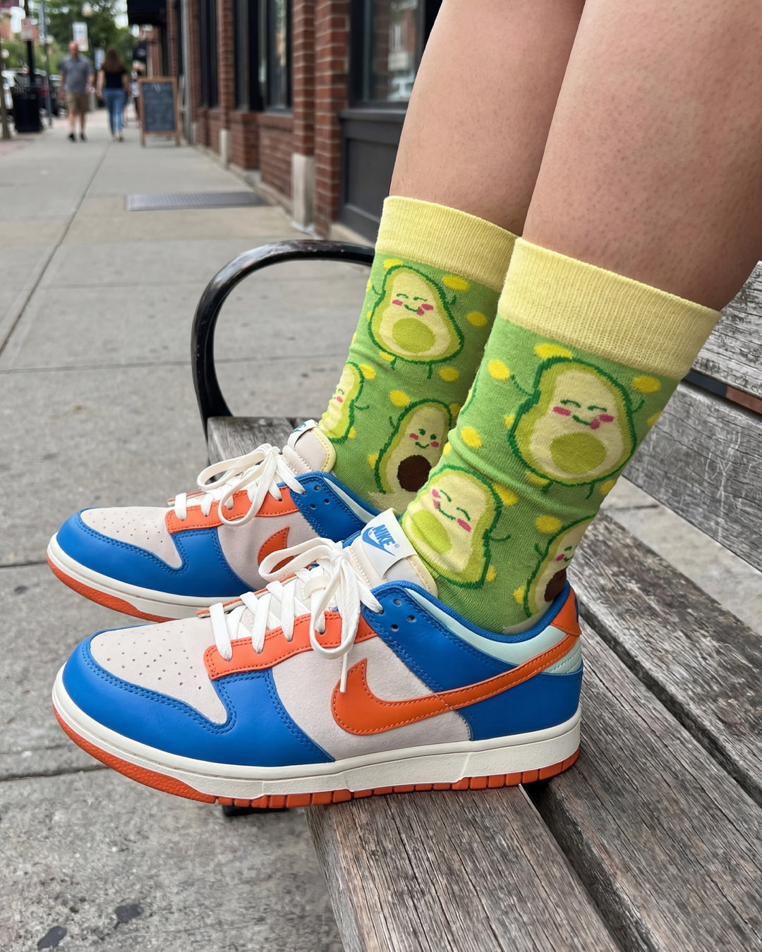 Socksop Avocado crew socks worn outdoors — foodie green-toned pattern paired with sneakers