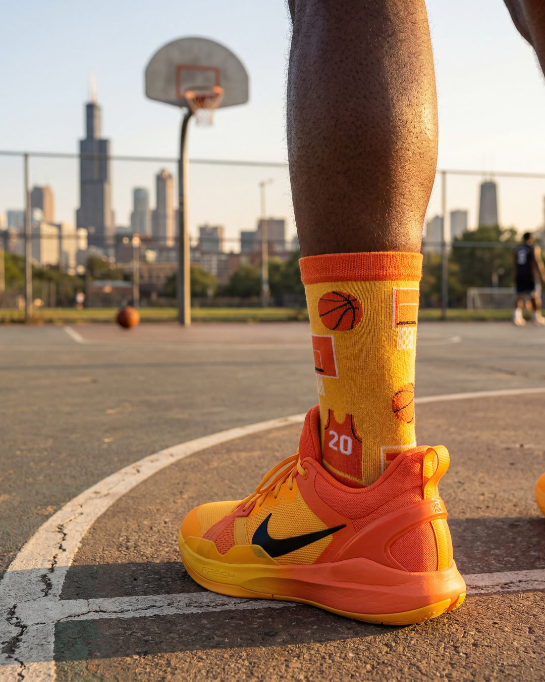 Socksop Basketball crew socks worn outdoors — bright orange court-themed pattern paired with sneakers