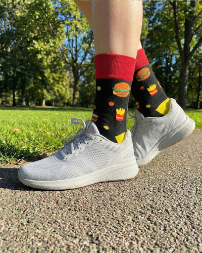 Socksop Burger crew socks worn outdoors — diner-themed pattern paired with sneakers