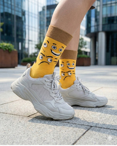 Socksop Emoji crew socks worn outdoors — bright yellow expressive face pattern paired with sneakers