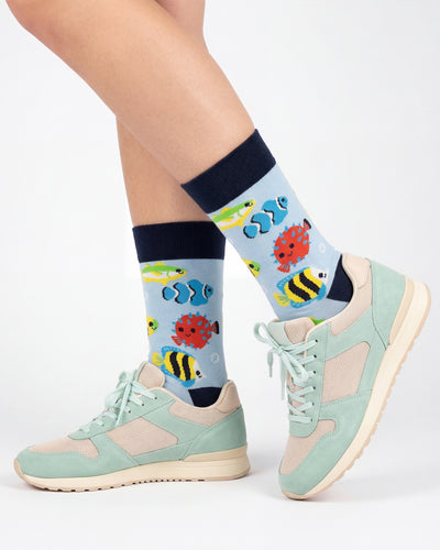 Socksop Fish crew socks studio shot — tropical reef fish in red yellow and blue on light blue cotton