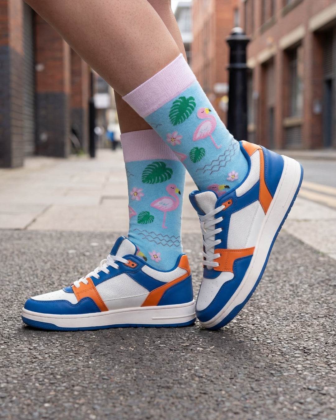 Socksop Flamingo crew socks worn outdoors — vacation-ready pink flamingo pattern paired with sandals