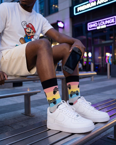 Socksop Gamer crew socks worn outdoors — colorful gamer-themed pattern paired with sneakers